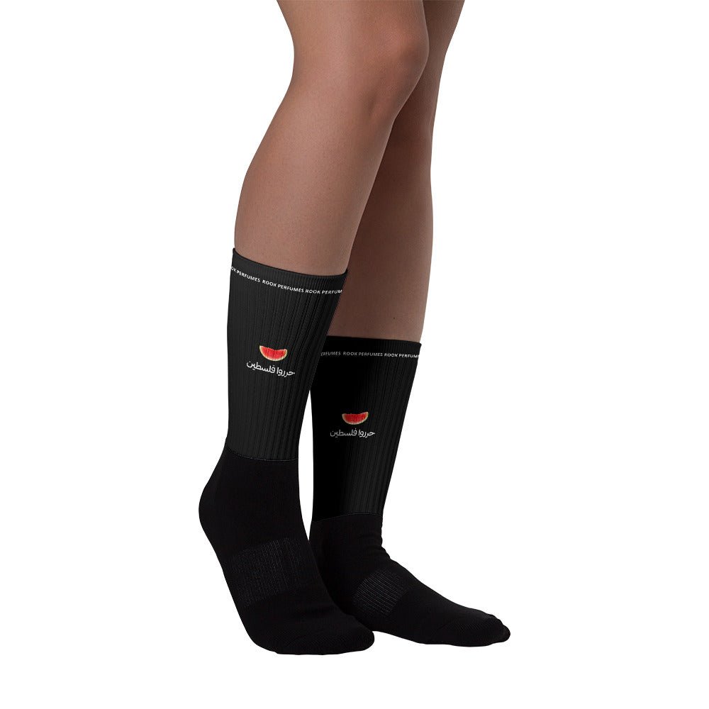 Pair of bright green watermelon socks with red and black seed patterns, designed for unisex wear by Rook Perfumes.
